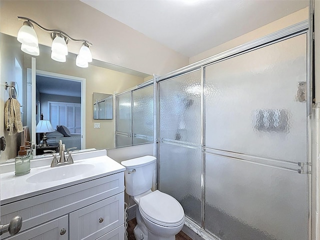 full bathroom with vanity, toilet, and a stall shower