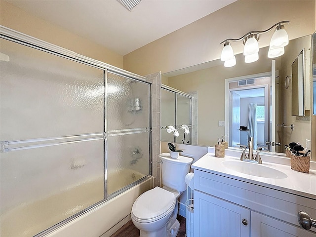 bathroom with visible vents, combined bath / shower with glass door, toilet, and vanity