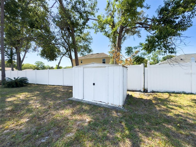 view of yard featuring a fenced backyard, an outbuilding, and a shed