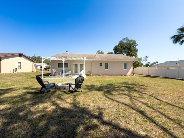 back of property featuring french doors, a lawn, a patio area, fence, and a fire pit