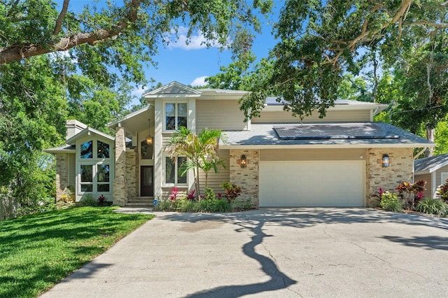 520 Lafayette Blvd, Oldsmar, FL 34677 - mid-century home with roof mounted solar panels, concrete driveway, brick siding, and a front yard