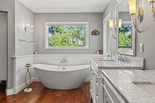 520 Lafayette Blvd, Oldsmar, FL 34677 - bathroom featuring baseboards, a soaking tub, vanity, and wood finished floors