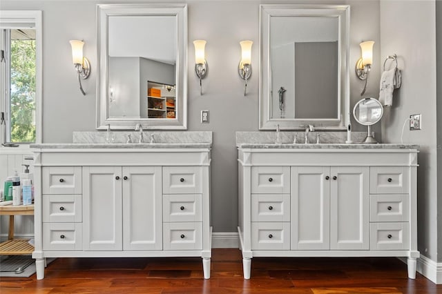520 Lafayette Blvd, Oldsmar, FL 34677 - full bathroom with baseboards, two vanities, a sink, and wood finished floors