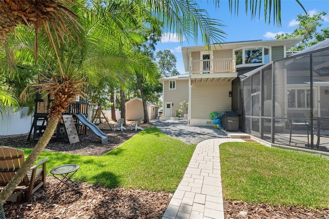 520 Lafayette Blvd, Oldsmar, FL 34677 - back of house featuring a lawn, an outbuilding, a shed, a playground, and a lanai