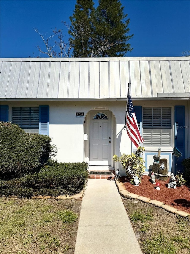 4264 Tamargo Dr Unit 3, New Port Richey, FL 34652 - doorway to property featuring metal roof, a standing seam roof, and stucco siding