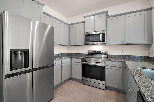 4106 NW 44th Cir, Ocala, FL 34482 - kitchen with stainless steel appliances, light tile patterned floors, gray cabinets, and dark stone countertops