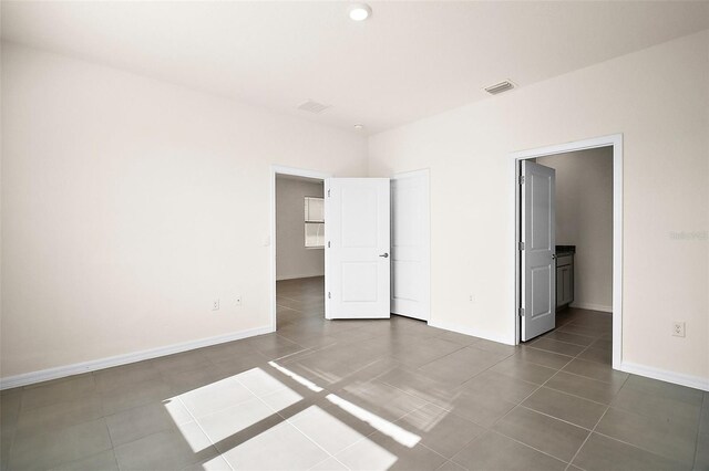 4106 NW 44th Cir, Ocala, FL 34482 - unfurnished bedroom with visible vents, dark tile patterned floors, and baseboards