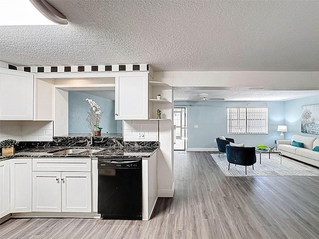 kitchen featuring a textured ceiling, light wood-style flooring, black dishwasher, and open floor plan