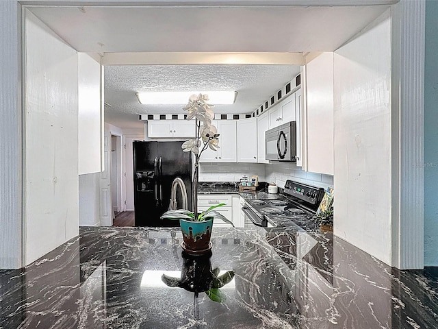 kitchen with dark stone counters, white cabinets, and black appliances