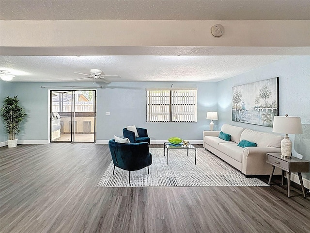 living room featuring baseboards, a textured ceiling, and wood finished floors