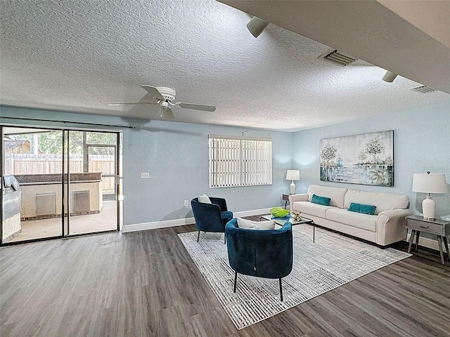 living area with baseboards, ceiling fan, wood finished floors, and a healthy amount of sunlight