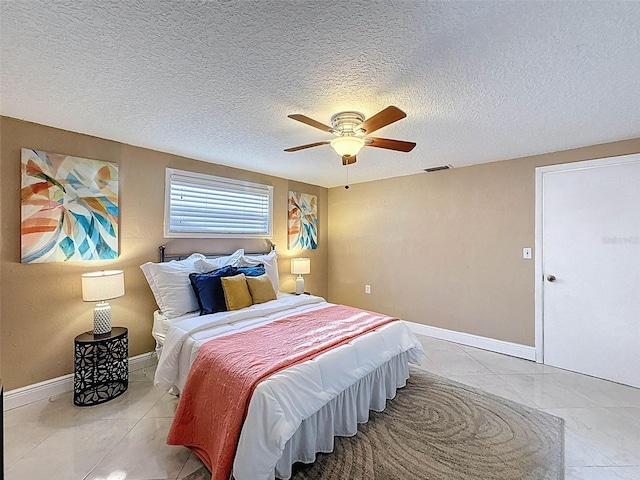 bedroom with baseboards, ceiling fan, a textured ceiling, and visible vents