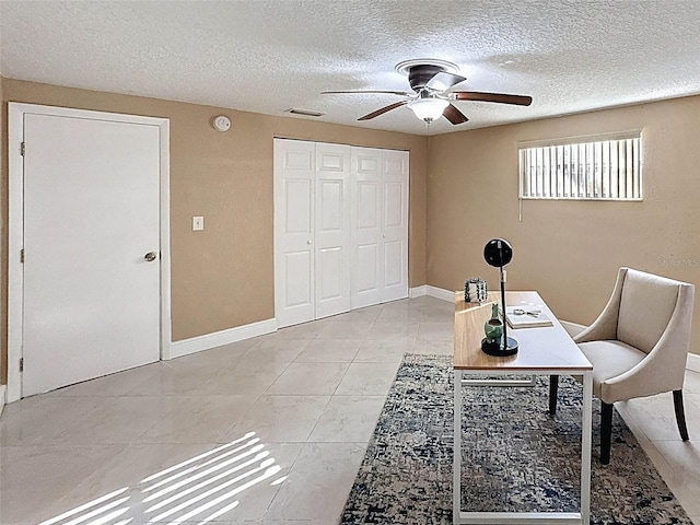 office featuring visible vents, baseboards, ceiling fan, a textured ceiling, and light tile patterned floors