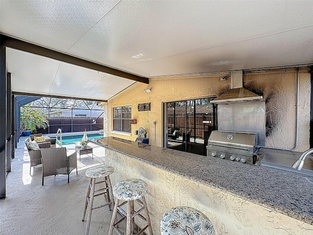 view of patio featuring a grill, a fenced in pool, outdoor wet bar, exterior kitchen, and a lanai