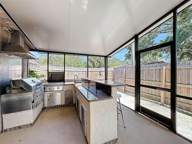 sunroom with a sink, exterior kitchen, and a healthy amount of sunlight