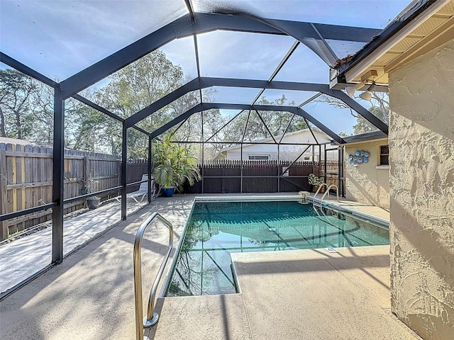 view of swimming pool featuring a fenced in pool, a fenced backyard, glass enclosure, and a patio area