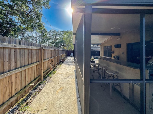 view of side of home featuring a fenced backyard and outdoor dry bar
