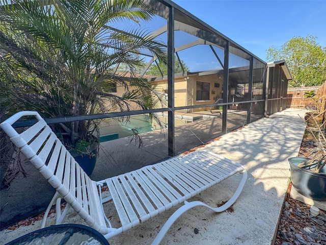 pool featuring a fenced backyard, glass enclosure, and a patio area