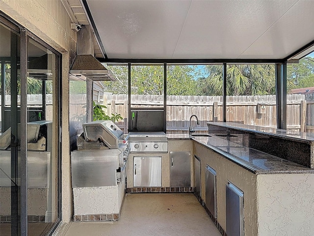 view of patio featuring fence, a sink, and area for grilling