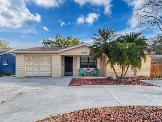 single story home featuring an attached garage, concrete driveway, and brick siding