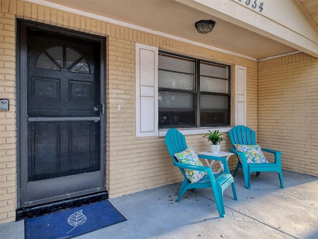 entrance to property featuring brick siding