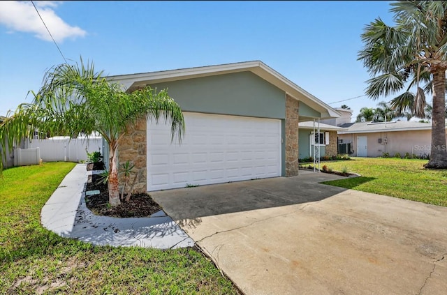 2175 Edythe Dr, Dunedin, FL 34698 - view of front of house featuring stone siding, a garage, driveway, and stucco siding