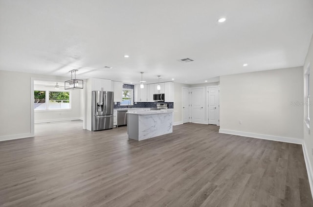 2175 Edythe Dr, Dunedin, FL 34698 - kitchen with stainless steel appliances, recessed lighting, a kitchen island, white cabinets, and open floor plan