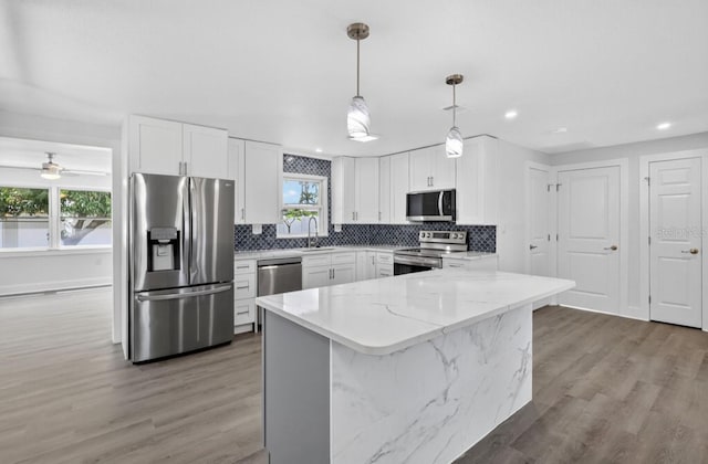 2175 Edythe Dr, Dunedin, FL 34698 - kitchen with appliances with stainless steel finishes, healthy amount of natural light, backsplash, light stone countertops, and recessed lighting