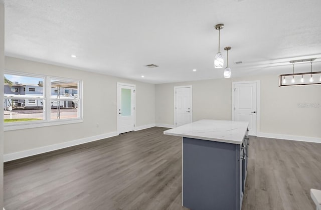 2175 Edythe Dr, Dunedin, FL 34698 - kitchen with gray cabinetry, a center island, dark wood-type flooring, light stone countertops, and recessed lighting