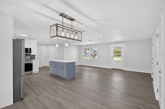 2175 Edythe Dr, Dunedin, FL 34698 - kitchen featuring stainless steel appliances, dark wood-type flooring, light countertops, a center island, and recessed lighting