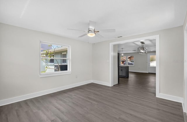 2175 Edythe Dr, Dunedin, FL 34698 - empty room with dark wood finished floors, healthy amount of natural light, and a ceiling fan