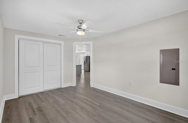 2175 Edythe Dr, Dunedin, FL 34698 - unfurnished bedroom featuring electric panel, stainless steel fridge with ice dispenser, wood finished floors, and a closet