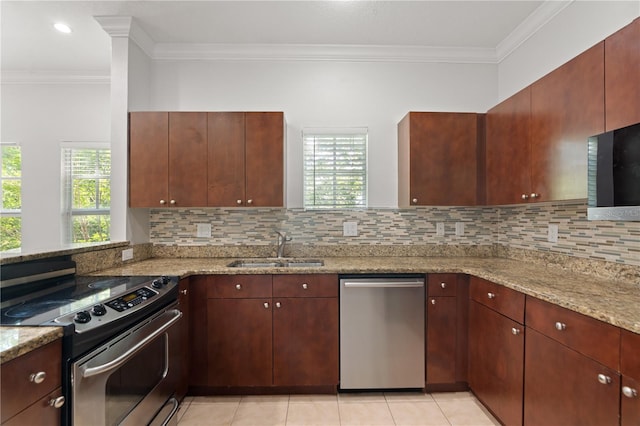 kitchen with crown molding, stainless steel appliances, light stone counters, and a sink