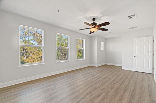 unfurnished room with baseboards, a wealth of natural light, and light wood finished floors