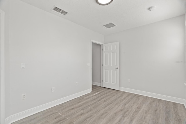 spare room with baseboards, visible vents, and light wood-style flooring