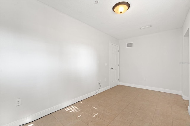 spare room with baseboards and visible vents