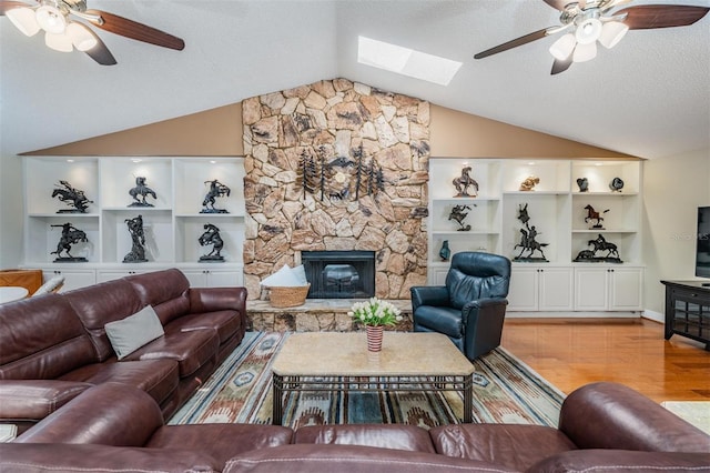 663 Turnberry Ct, Tarpon Springs, FL 34688 - living area featuring ceiling fan, light wood finished floors, vaulted ceiling with skylight, a fireplace, and a textured ceiling