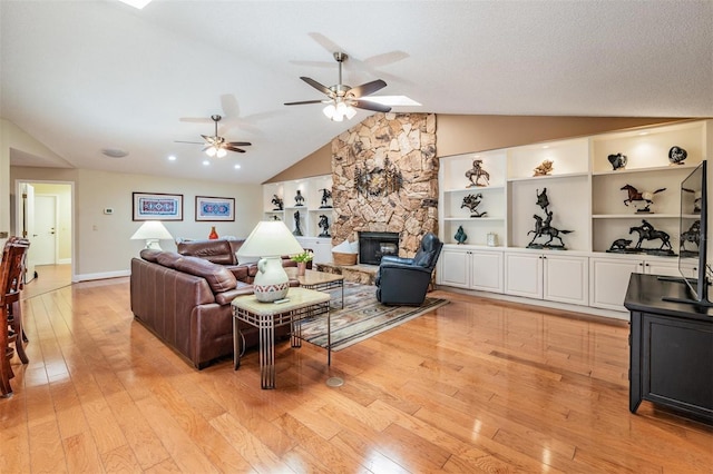 663 Turnberry Ct, Tarpon Springs, FL 34688 - living room featuring light wood-style floors, a fireplace, a ceiling fan, and lofted ceiling with skylight
