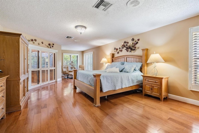 663 Turnberry Ct, Tarpon Springs, FL 34688 - bedroom featuring visible vents, a textured ceiling, light wood-style flooring, and baseboards