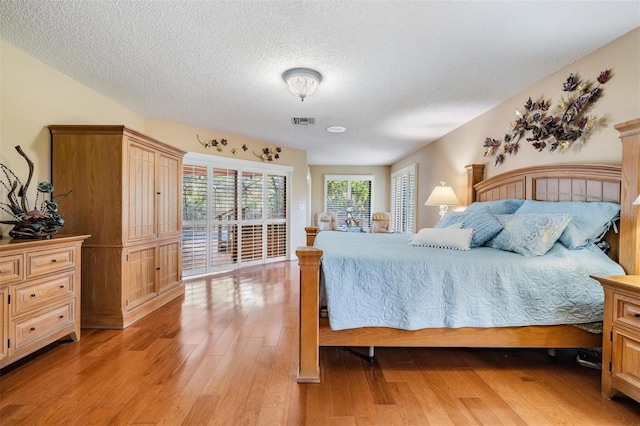663 Turnberry Ct, Tarpon Springs, FL 34688 - bedroom with light wood-type flooring, access to outside, a textured ceiling, and visible vents