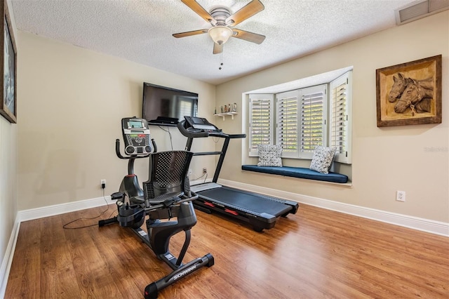 663 Turnberry Ct, Tarpon Springs, FL 34688 - exercise area with visible vents, a textured ceiling, baseboards, and wood finished floors