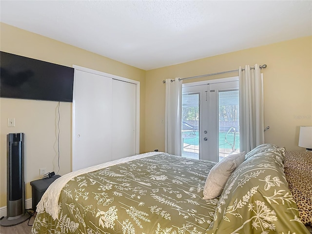 bedroom featuring access to outside, a closet, and wood finished floors