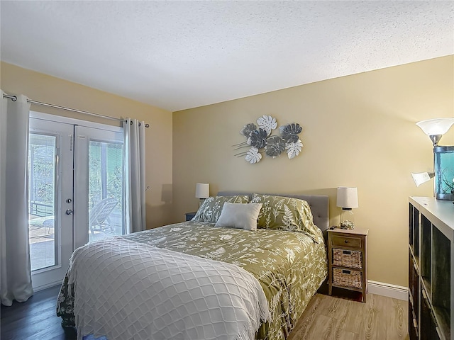 bedroom with multiple windows, access to outside, and wood finished floors