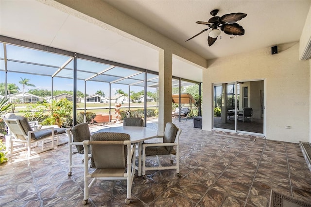 view of patio featuring ceiling fan, glass enclosure, visible vents, a residential view, and outdoor dining space