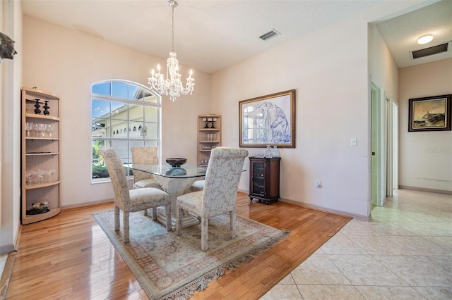 dining space with an inviting chandelier, baseboards, light wood-style floors, and visible vents