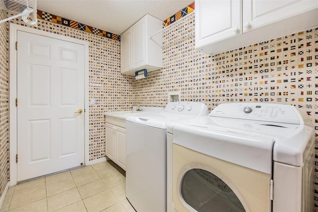 washroom featuring washing machine and clothes dryer, light tile patterned flooring, a sink, and cabinet space