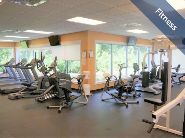 gym with visible vents, a paneled ceiling, and a wealth of natural light