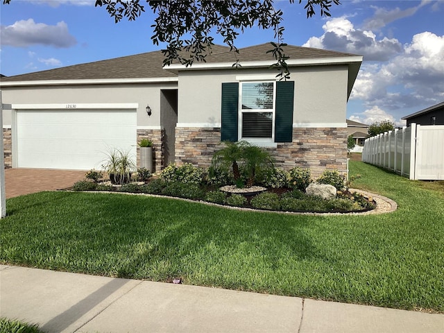 12630 Aston Dr, Hudson, FL 34669 - view of front of house featuring a garage, fence, stone siding, and stucco siding
