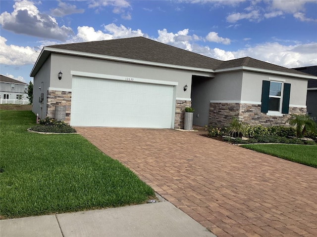 12630 Aston Dr, Hudson, FL 34669 - view of front facade featuring decorative driveway, a front lawn, stucco siding, and stone siding