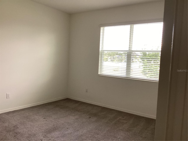 12630 Aston Dr, Hudson, FL 34669 - empty room featuring baseboards and dark colored carpet